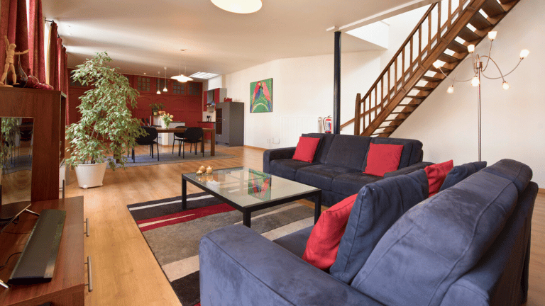 Spacious living room in a city center holiday rental in Bruges with a dining table, seating area, kitchen, television and air conditioning. Two persons apartment.