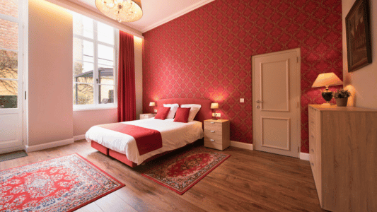 Spacious bedroom in a city center holiday rental in Bruges with a queen-size bed, large windows, modern furniture, and wooden floors. Four persons apartment.