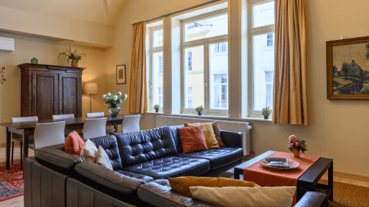 Spacious living room of holiday rental OLV in Bruges, featuring air conditioning. Perfect for six persons, part of De Drie Koningen apartments.