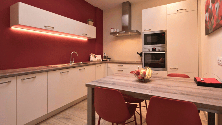 Fully equipped kitchen in a city center four persons apartment in Bruges with an espresso machine, oven, microwave, dishwasher, fridge, and freezer.