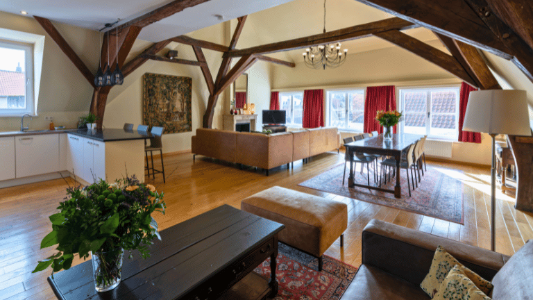 Spacious living room in a city center eight persons apartment in Bruges with a dining table, seating area, television, and air conditioning.