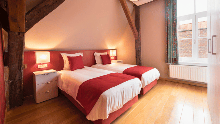 Twin room in a city center apartment in Bruges with modern furniture, and wooden floors.