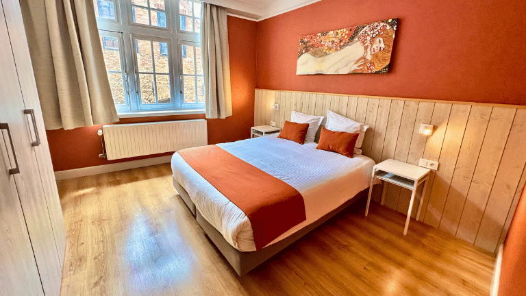 Spacious bedroom in a city center eight persons holiday rental in Bruges with a queen-size bed, modern furniture, and air conditioning.