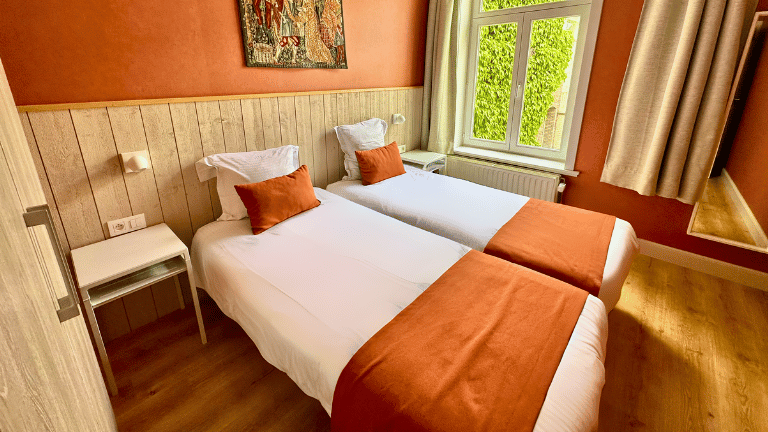 Twin room in a city center apartment in Bruges with modern furniture, and air conditioning.