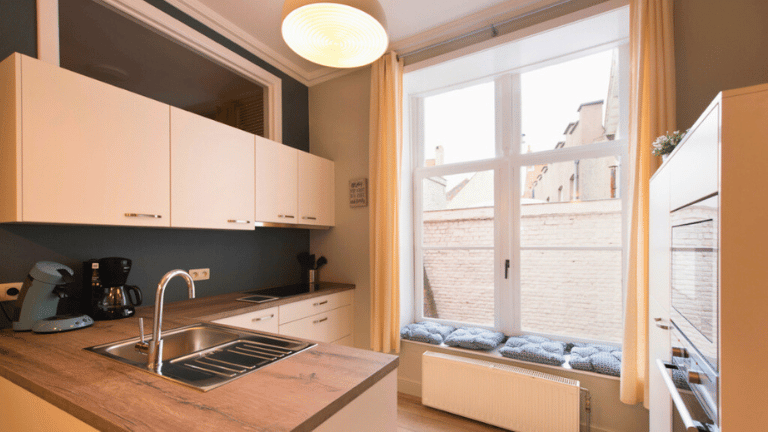 Fully equipped kitchen in a city center four persons apartment in Bruges with an espresso machine, oven, microwave, dishwasher, fridge, and freezer.
