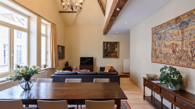 Spacious living room in a city center holiday rental in Bruges with a dining table, seating area, television, and air conditioning. Six persons apartment.